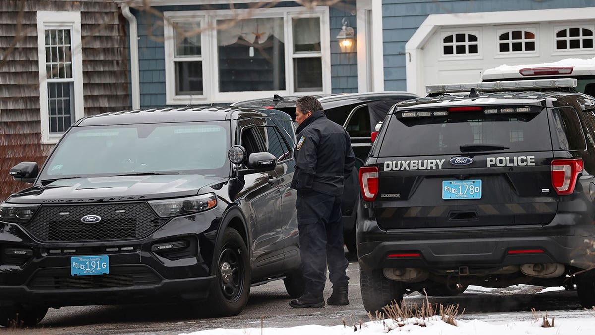 La police du MA garée devant avec des véhicules d'une maison du Massachusetts
