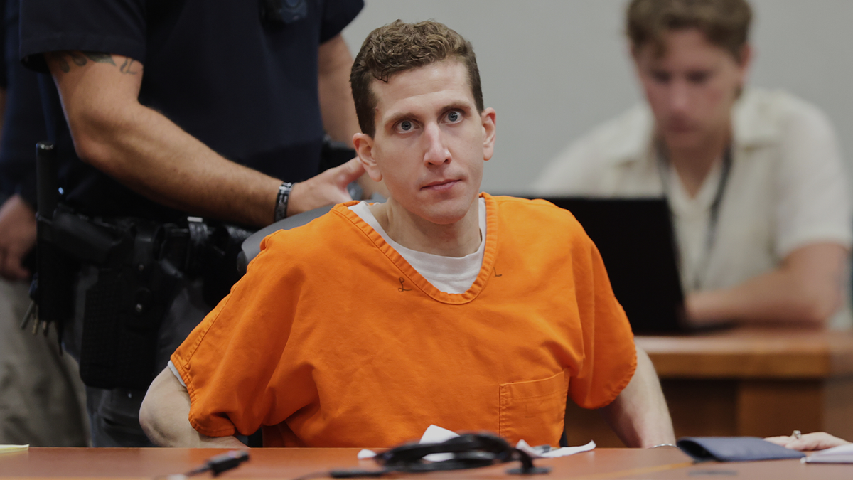 Bryan Kohberger ajuste son siège au palais de justice du comté d'Ada, portant une combinaison de prison orange sur un t-shirt blanc