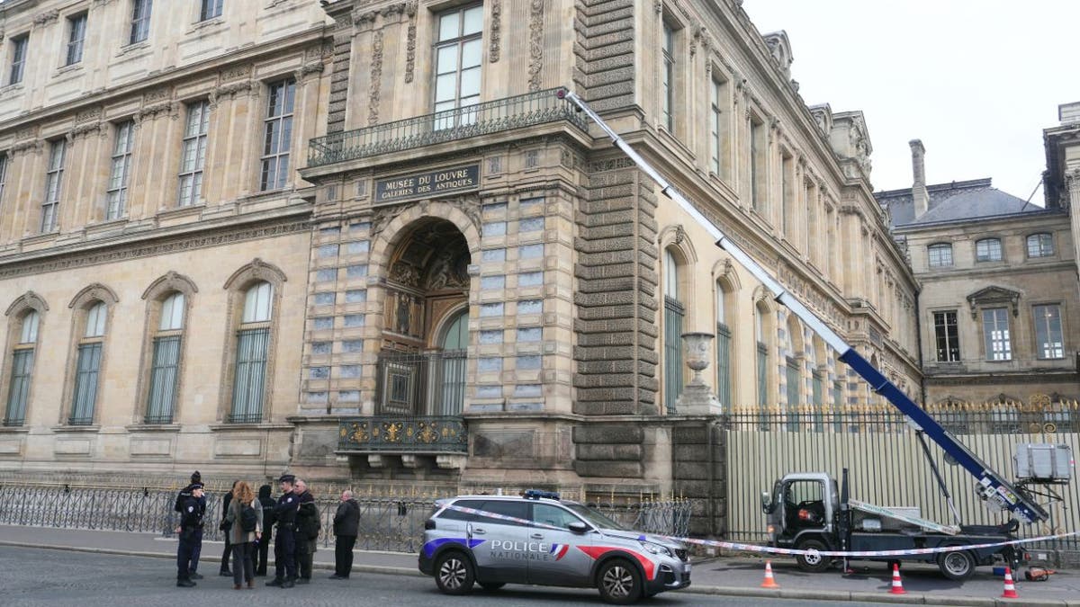 Police et ascenseur en mouvement devant le musée du Louvre suite au vol d'un bijou à Paris.