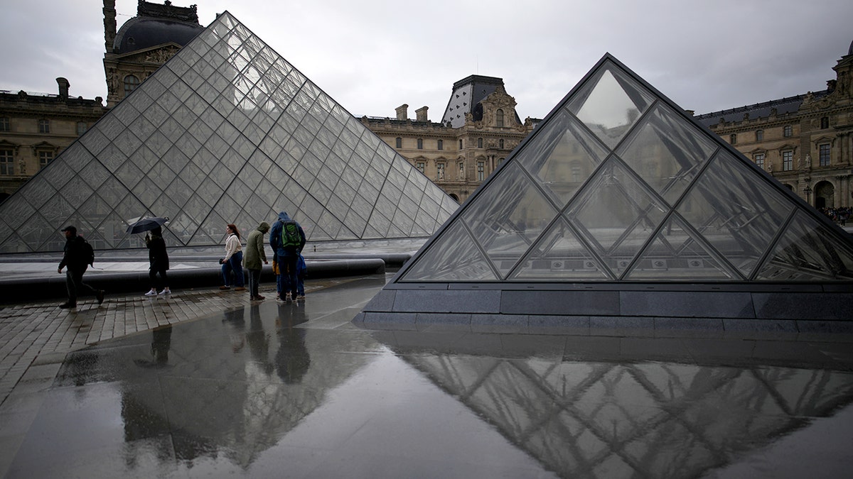 Promeneurs dans la cour du musée du Louvre