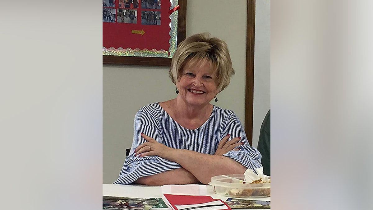 Anita Avers souriante sur une photo de 2021, vêtue d'un chemisier rayé.