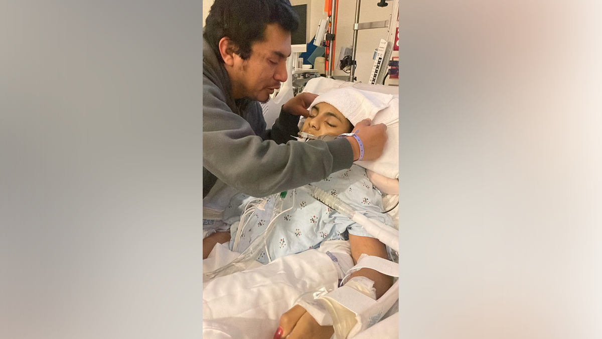 Un membre de la famille est assis à côté de Khimberly Zavaleta dans un lit d'hôpital après qu'elle ait subi un traumatisme crânien.