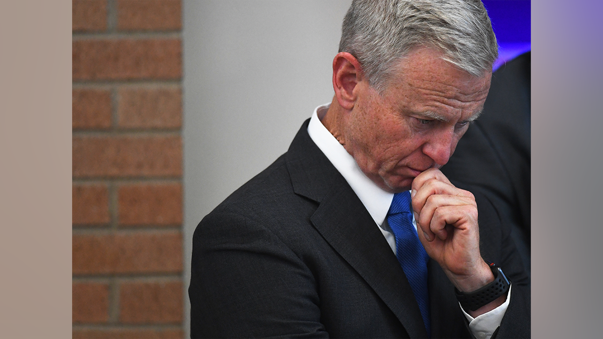 George Brauchler baissant les yeux.