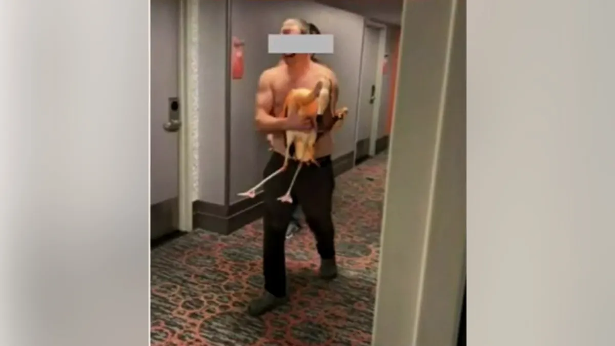 Un homme tenant un flamant rose dans un couloir.
