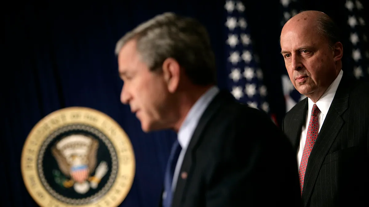 John Negroponte regarde pendant que le président Bush tient une conférence de presse