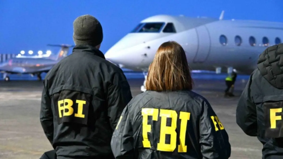 Agents du FBI debout sur le tarmac d'un aéroport près d'un jet privé la nuit.